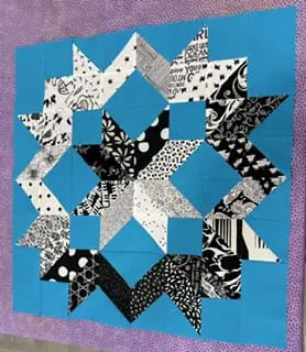 Black and white star quilt block with blue background and purple border - Looney Bin Quilting